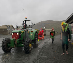 Here comes Santa — Sleigh is pulled by a tractor while expeditioners dressed as Santa’s elves look on and laugh