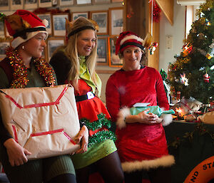 Santa’s helpers Kelly, Jaimie and Lauren are dressed as elves and holding presents