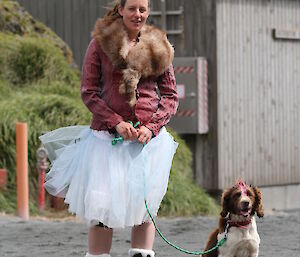 Dana in tutu and faux fur stoale poses with dog