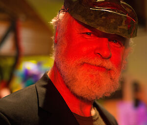 Close up of Gunny who has a tidy white beard and a mask resting on his head