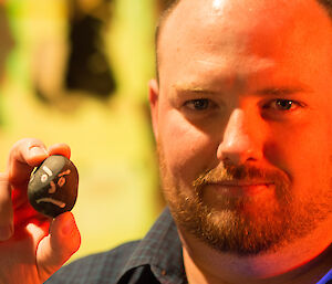 Matt holding up a stone with a face painted on it