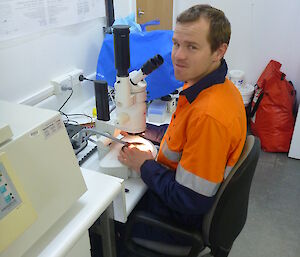 Expeditioner sitting at a desk ready to inspect soil samples