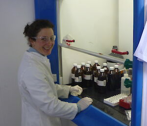 Female expeditioner standing in front of bottle cabinet in the science lab