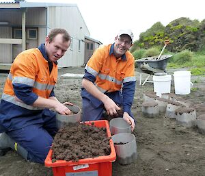 Two expeditioners placing soil in plastic bins