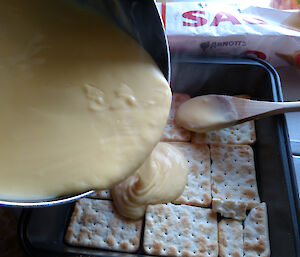 Close up of custard poured on biscuit base