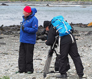Camerman and a reporter filming a segment on the coast