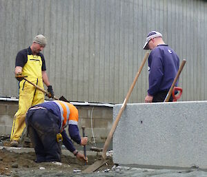 Three expeditioners digging a large hole