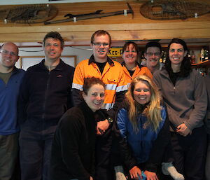 Nine expeditioners standing in front of the camera smiling