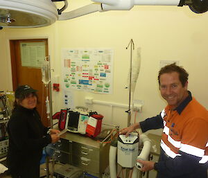 Two expeditioners standing alongside medical equipment