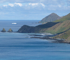 View down the coast, blue ocean and a white ship in the background