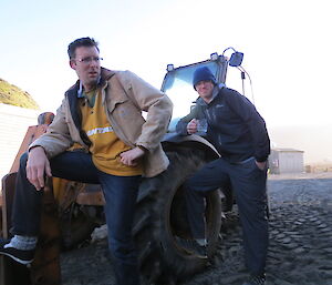 Two expeditioners looking very cheeky like farmers in front of their tractor