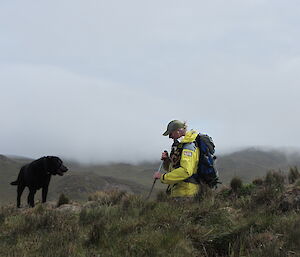 Expeditioner and his black labrador on a steel slope