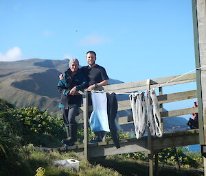 Male and female expeditioner standing together on the ramp of the hut, clothes drying in the sun