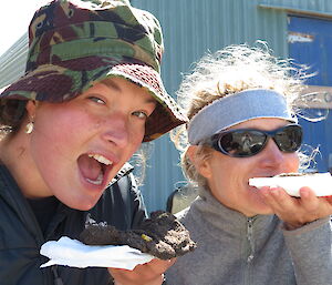 Close-up of two females pretending to eat mud pies