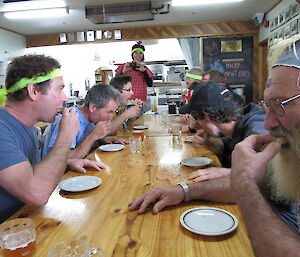 Expeditioners sitting at the table lined up ready to eat Weet-Bix in a competition