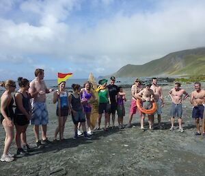 15 expeditioners in crazy costumes lined up to run into the water