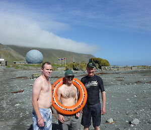 Three expeditioners posing for the camera, one with a life bouy around his waist
