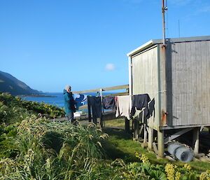 Expeditioner hanging out the washing at one of the huts in a sunny day