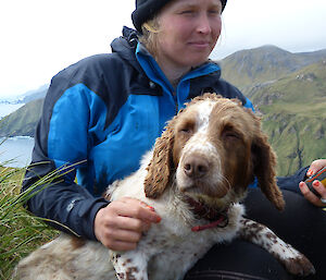 Female expeditioner with her arms around a spring spaniel dog