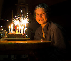 Female expeditioner looking at her cake, cake has a sparkler