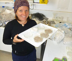 Expeditioner in science lab holding a tray seeds in a dish