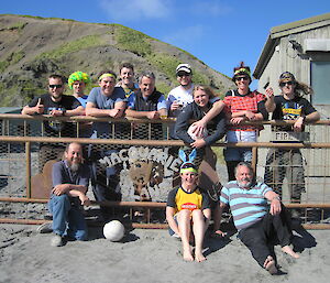 12 expeditioners standing next to a gate looking at the camera