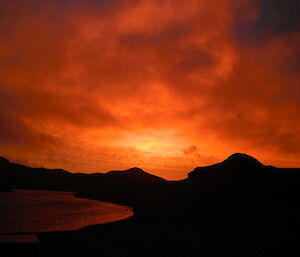 Bright orange and red colours in the sky, reflection or red on lake