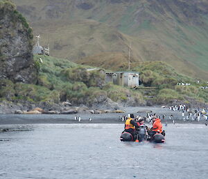 Boat heads towards the beach with field hut in background