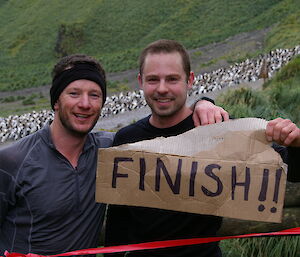 Runners holding a finish sign