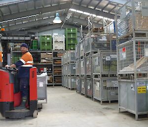 Expeditioner in the warehouse driving a fork lift