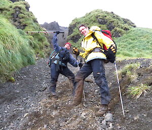 Two expeditioners looking very excited at the base of a scree slope