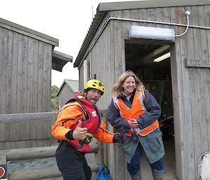 Two expeditioners standing in front of timber building