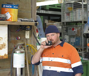 Male expeditioner holding a radio