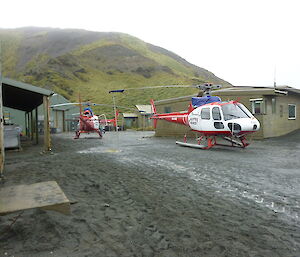 Three helicopters in the middle of buildings