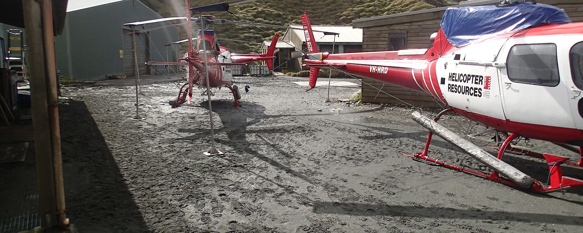 Red and white helicopters in the square at the centre of the station close to buildings