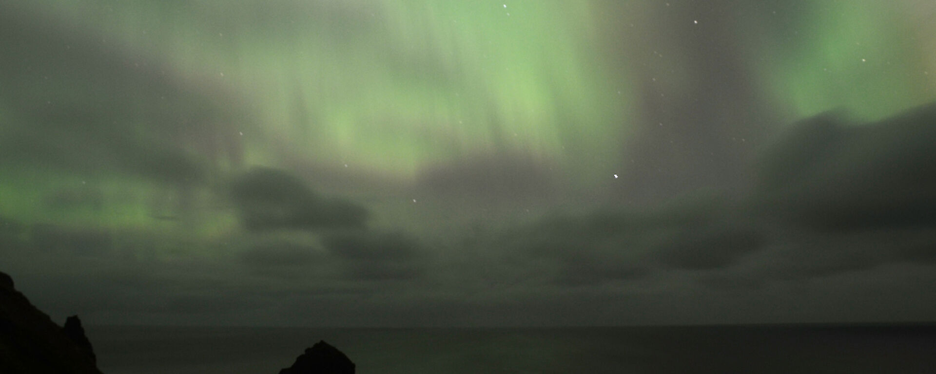 Aurora australis or southern lights, appearing like a greenish silk curtain, as seen from the Ham hut looking southeast over Buckles Bay