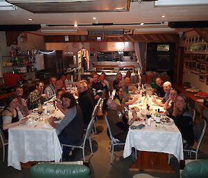 Saturday night special Chinese dinner, with 23 expeditioners sitting around two rows of tables. The tables are adorned with white linen tablecloths