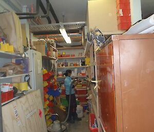 Patty tidying the shelves of the storeroom in the Carpenters workshop