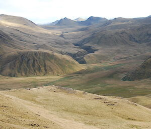 Approaching Green Gorge looking toward Pyramid Peak. A scene filled with green grassed hills, peaks and valleys