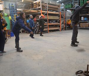 Karen and Mike playing quoits in the green store with many other people in the background playing other games