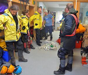 All second team members in upstairs in an office awaiting for instructions all are dressed on uniforms behind them on each sides are shelves