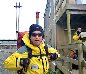 Aaron in the photo with his sunglasses, beanie and holding on to the straps of his back pack standing outside the decking area