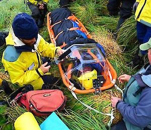 Tom secured in the stretcher and team getting ready to move him