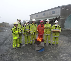 Fire team warming their hands by the fire contained in the drum in the middle of the court yard