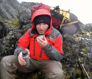 Taking a break on the Island Lake track. Aaron sitting in the lee of a large rock having a hot cup of coffee