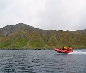 A IRB in the foreground with the rugged hilly coast in the background. There are many small streams and valleys on the slopes.