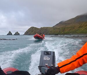 Taken from the stern of a IRB. The other IRB can be seen following in the wake. The rock stacks of the Nuggets and the rugged, steep slopes can be seen in the background