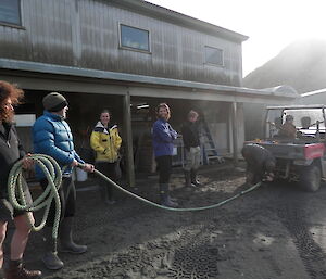 People standing outside of the carpenters work shop holding a rope attached to the buggy