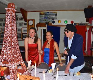 Leona Patty and John dressed up standing at the table looking at the Eifel Tower