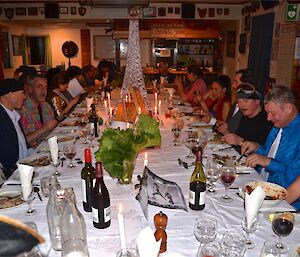 Everyone sitting at the table enjoying their meal the Eifel tower at the centre of the table and the big screan in the background with projected images